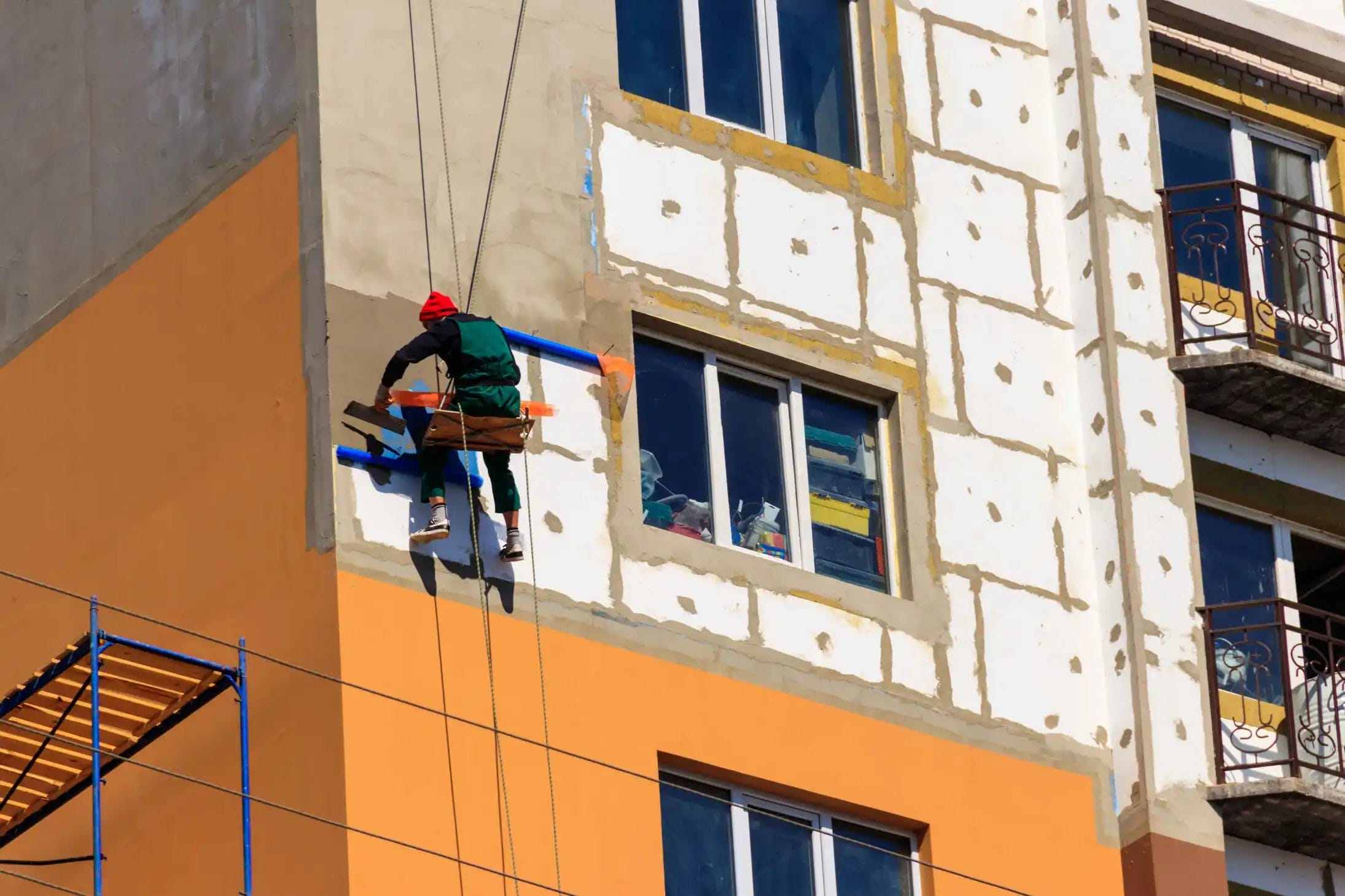 styrofoam-insulation-highrise-building-rope-access-working-concept-industrial-alpinism servicio de hidrolavado de grandes estructuras